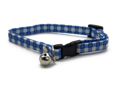 A blue and white gingham patterned cat collar with a small silver bell and black plastic buckle, shown on a white background.