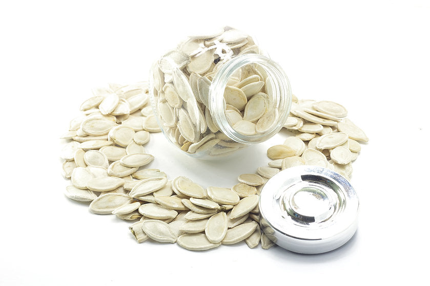 A jar fille with shelled pumpkin seeds