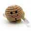 A small plush toy shaped like a round, ribbed beige character with black embroidered eyes and mouth, a red smile, and a white hangtag attached, photographed on a white background.