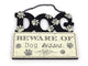 Decorative sign with 'Beware of Dog Kisses' text and paw prints on a white background