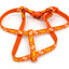 Orange dog harness with white paw print pattern on a white background