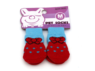Red and blue pet socks with a bow design on a purple packaging label.
