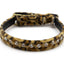 A leopard print collar with a row of clear rhinestones, photographed on a white background.