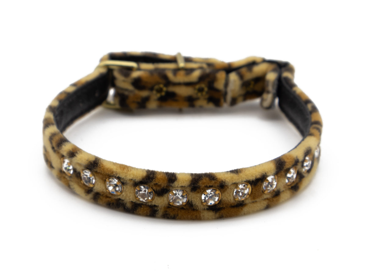 A leopard print collar with a row of clear rhinestones, photographed on a white background.