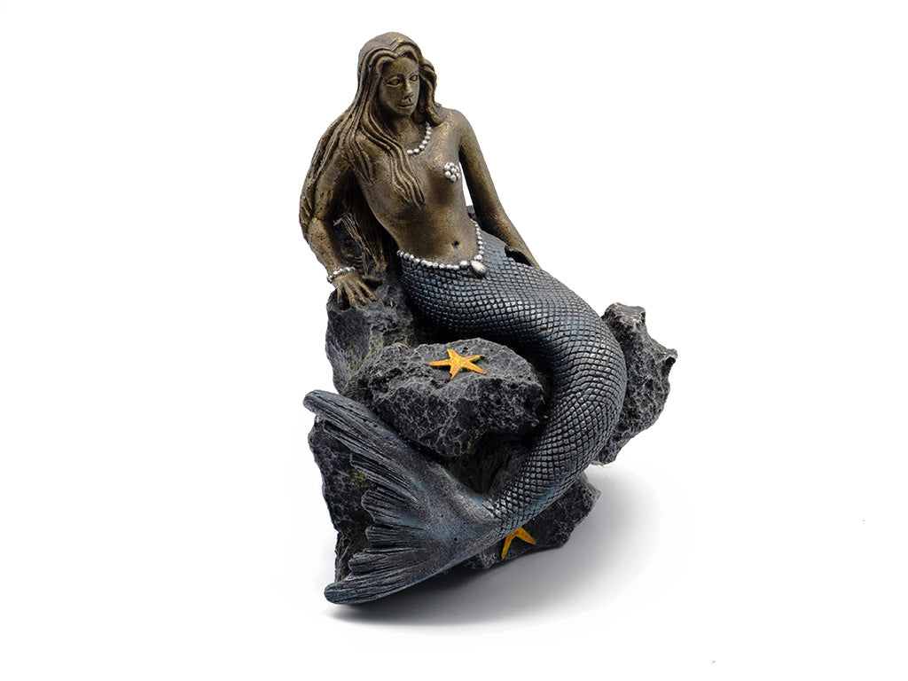 Mermaid figurine sitting on a rock with starfish, on a white background