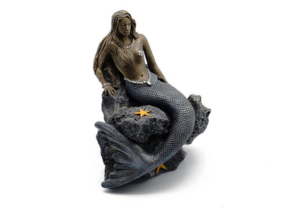 Mermaid figurine sitting on a rock with starfish, on a white background