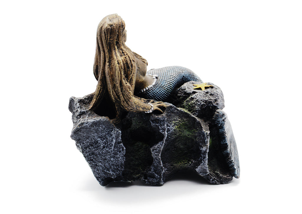 Decorative figurine of a mermaid on a rocky base with a white background