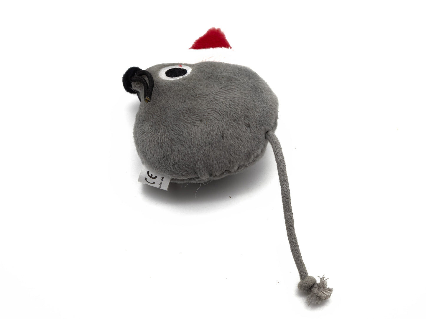 A gray plush toy shaped like a mouse with a long tail and a small red Santa hat, photographed on a white background.