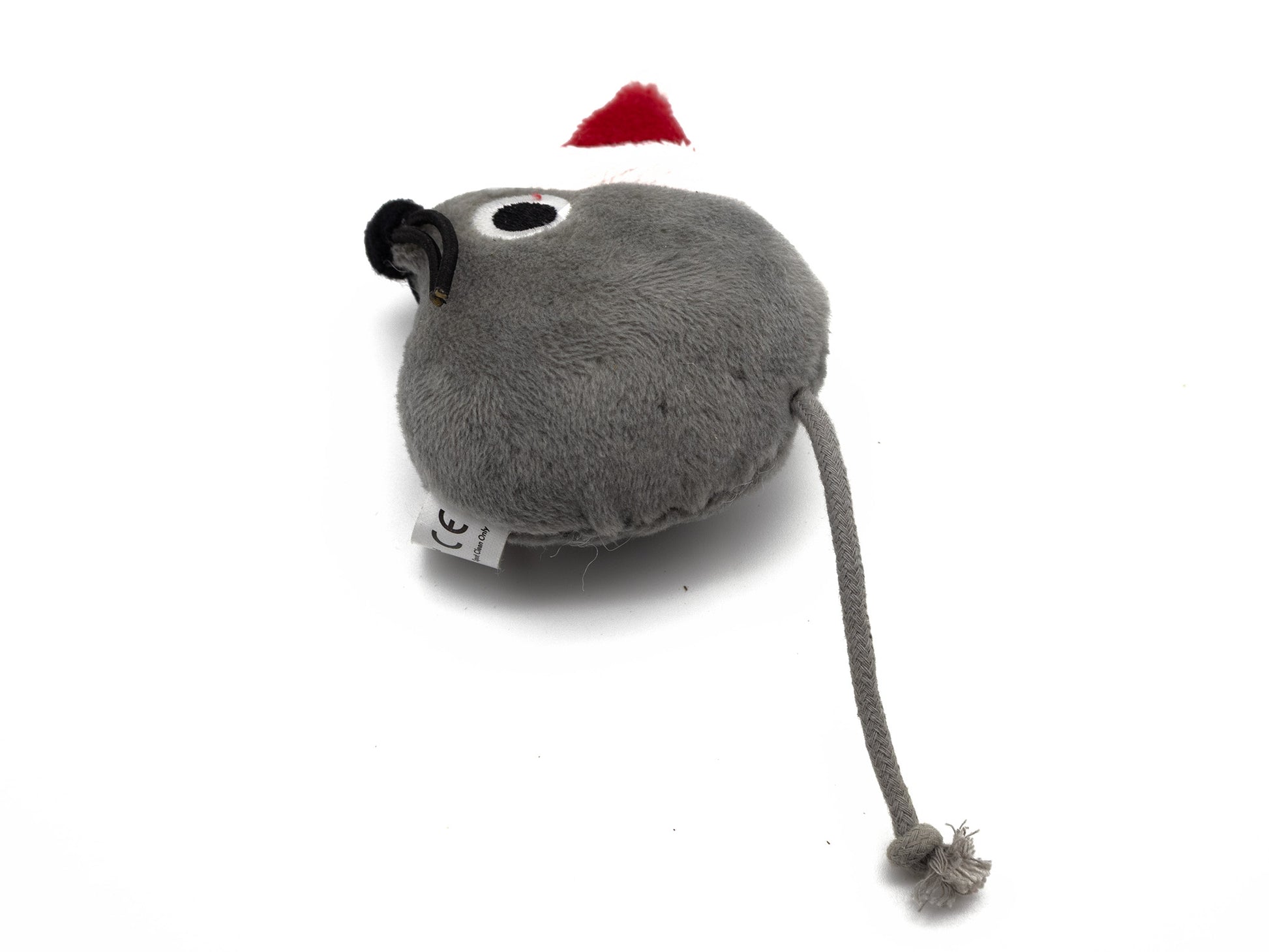 A gray plush toy shaped like a mouse with a long tail and a small red Santa hat, photographed on a white background.