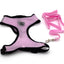 Pink dog harness and leash set on a white background