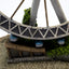 Model of a Ferris wheel with a small building underneath on a textured surface.